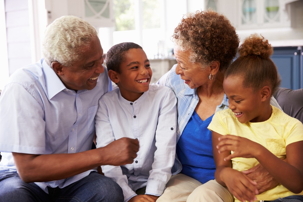 Grandparents sitting on the couch with their grandchildren
