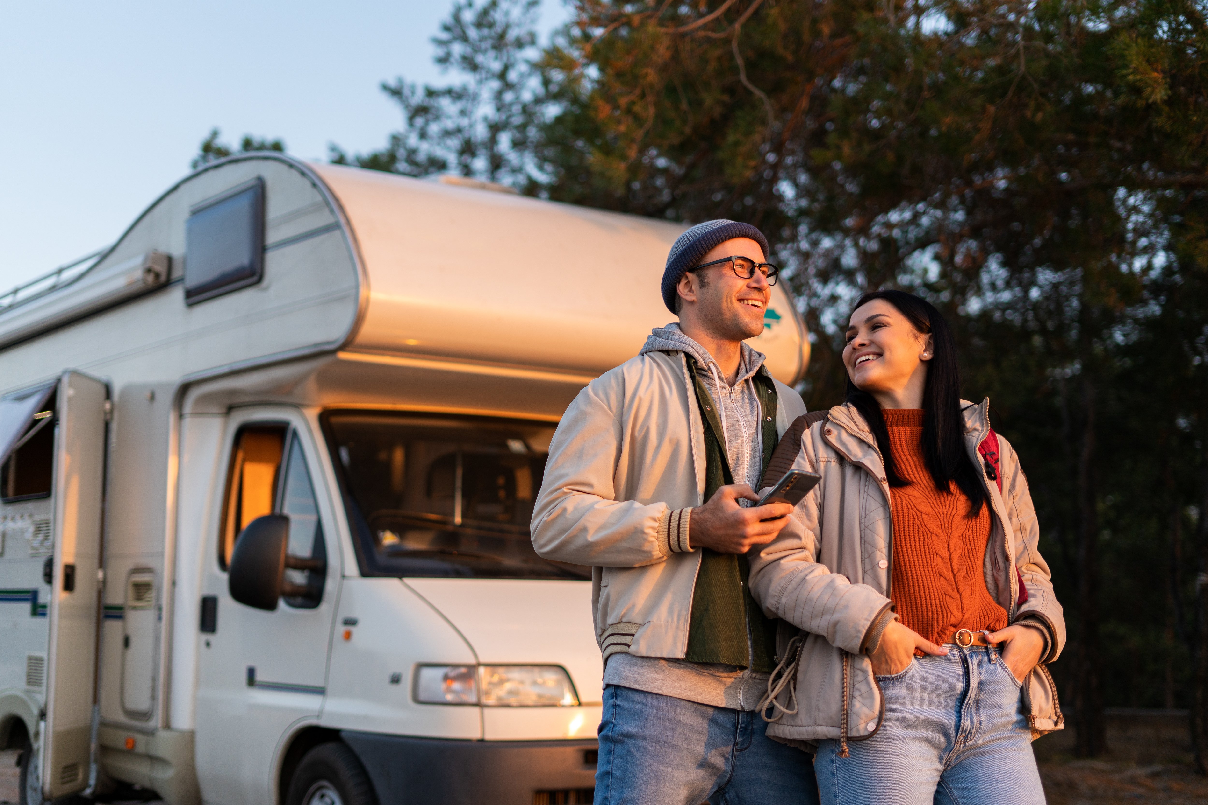 Couple embracing standing in front of their camper