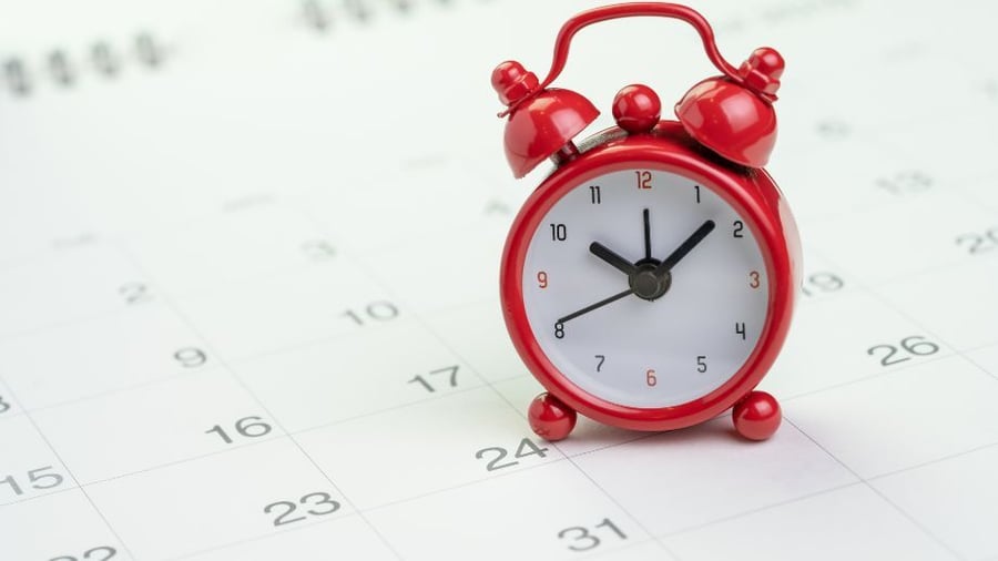 Calendar background with a red clock. Indicating that there may still be time to contribute to your 2025 IRA