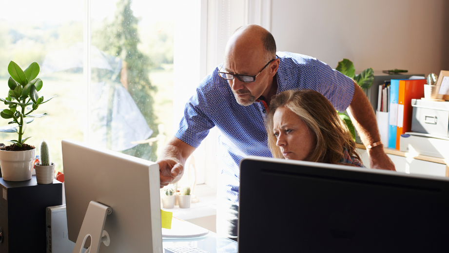 A couple looking at their computers while reviewing financial information during the homebuying process.