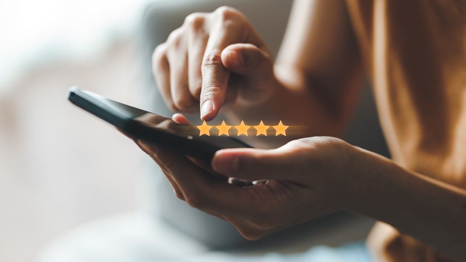 A woman holding a phone with a five‑star rating, representing trusted support throughout the homebuying process.