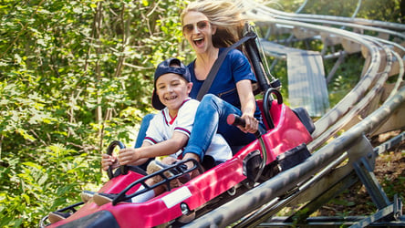 Mother and son riding a roller coaster in the summer time 