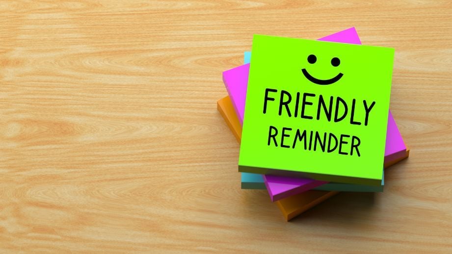 Stack of multi colored post it notes, with the top page reading Friendly Reminder. A happy face is also included. 