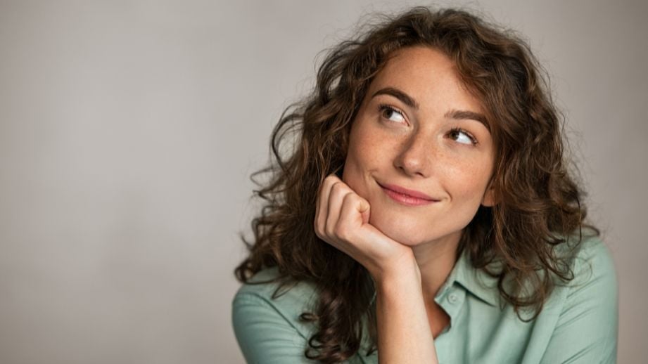 A middle aged woman looking into the sky, wondering if it is still worth contributing to her 2025 IRA. 