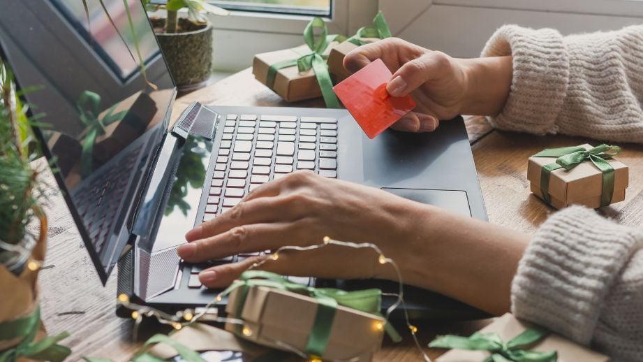 Woman using credit card to carefully shop online. Be aware of scammers.