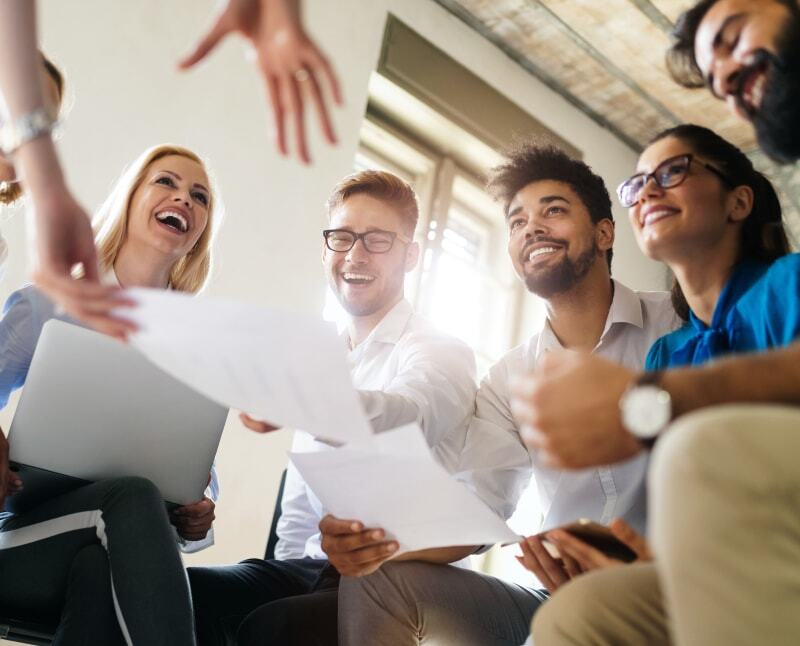 Team members in an office working together on a project. They are happy to feel valued, and they are encouraged by the energy of the whole team.