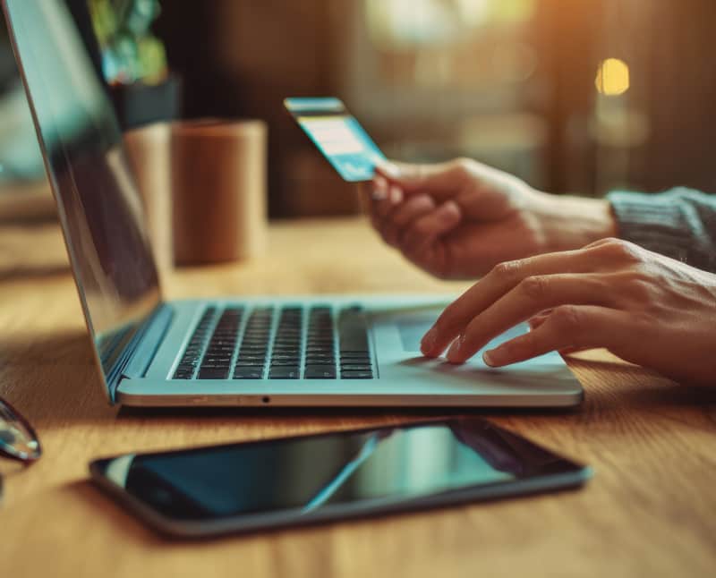 Business owner using their laptop to make a business purchase with their credit card.