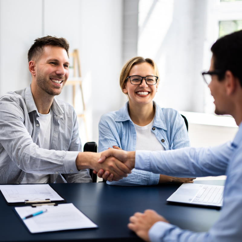 Happy couple working with a banking professional. They are getting personalized support for their banking needs.
