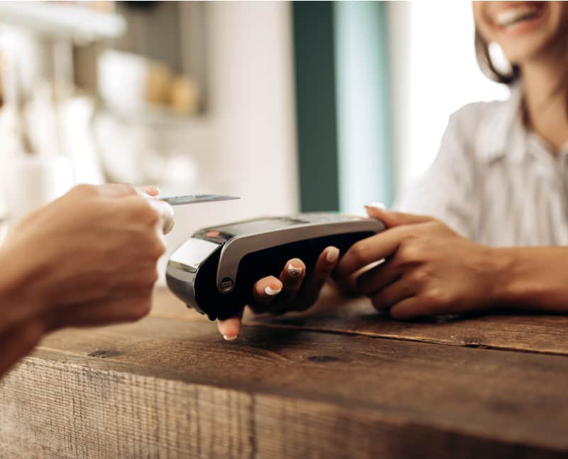 Customer is making a payment with his debit card at the store. The merchant is happy.