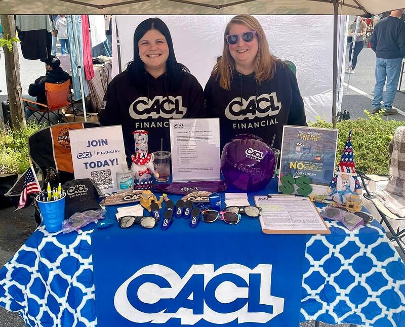 CACL FCU team members running a company booth at an event