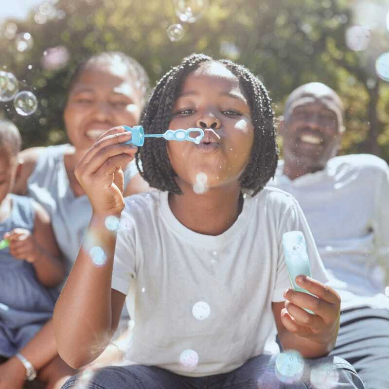 A Multiethnic family is happy and outside, enjoying the day and spending family time together. Experiencing financial freedom with the support of a credit union.