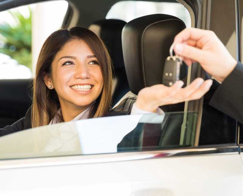 Happy woman getting the keys to a new car. Her financial goal is achieved.