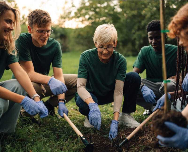 Caring volunteers planting a tree to show support and kindness for the local people and showing support to those who need it the most.